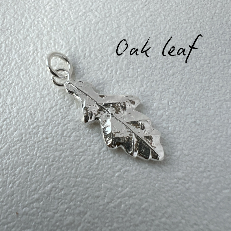 Silver leaf-shaped pendant on a light gray background with 'Oak leaf' text.