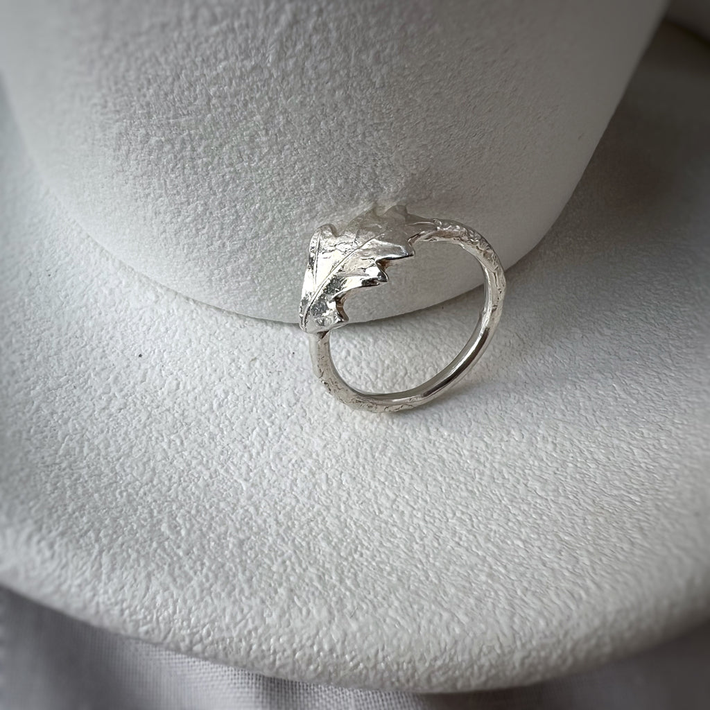 Silver oak leaf ring on white plate