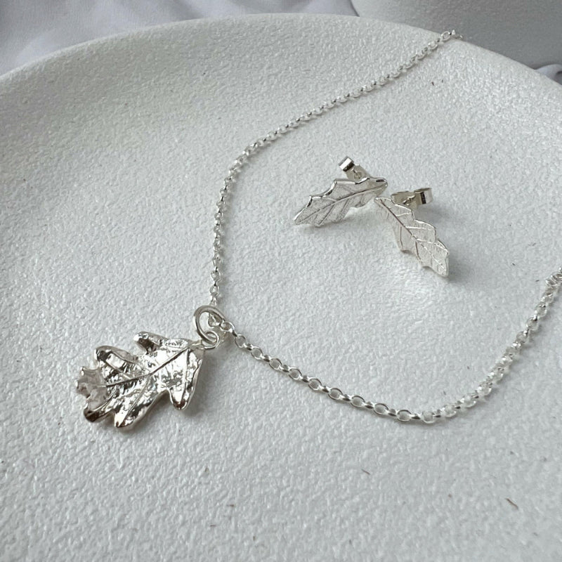 Silver Oak Leaf Pendant and Stud Earrings on White Plate