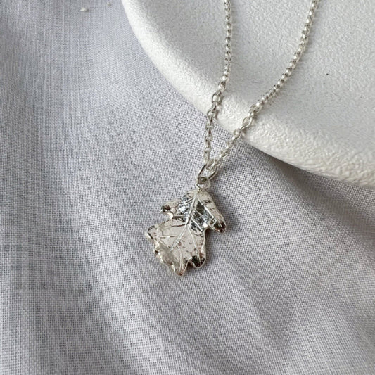 Silver oak leaf pendant on white background