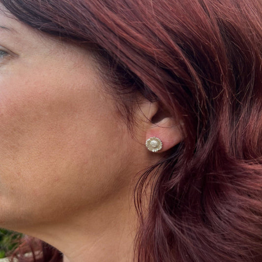 close up of ladies face wearing silver daisy stud earrings