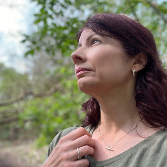 Woman in front of tree wearing organic textured silver jewellery