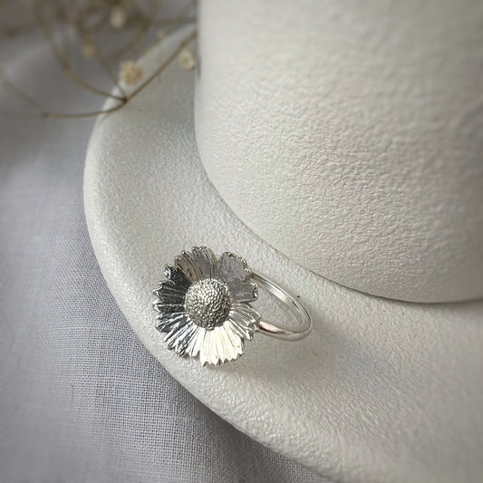 silver daisy ring on white plate