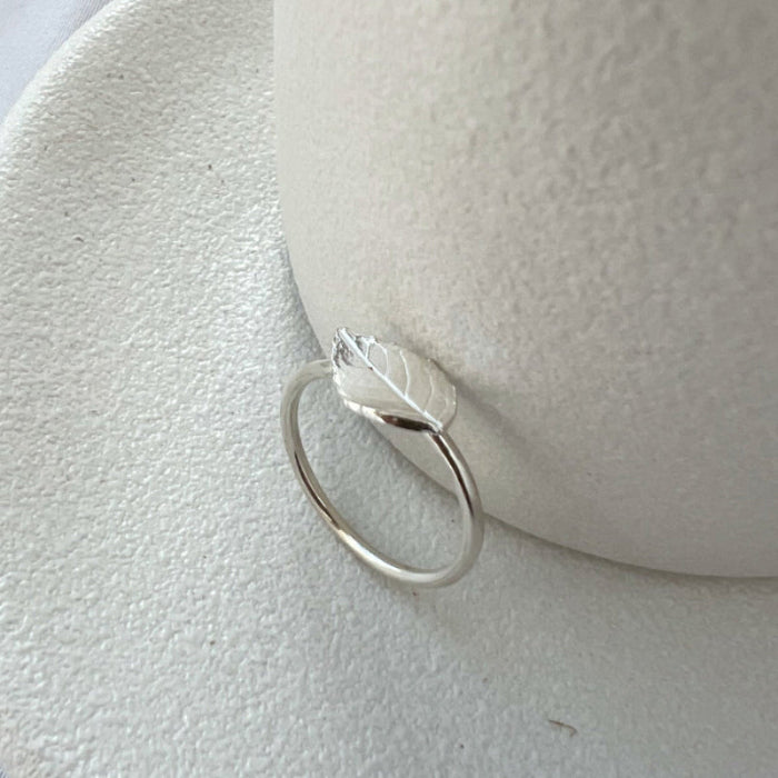 Silver rose leaf ring on white background