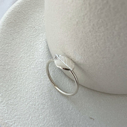 Silver rose leaf ring on white background