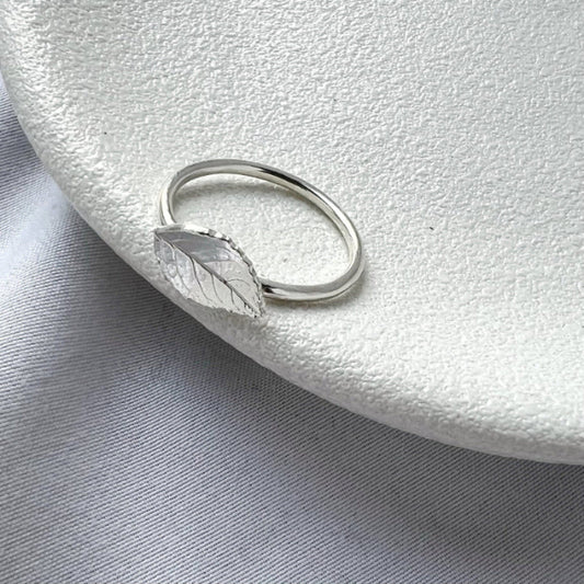 Tiny rose leaf ring on white plate