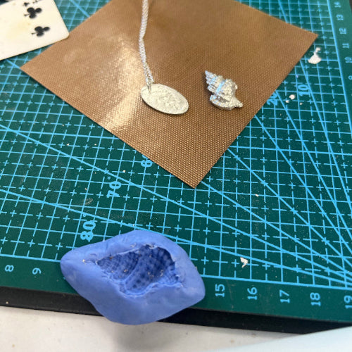 Blue mould and silver shell and necklace on green mat